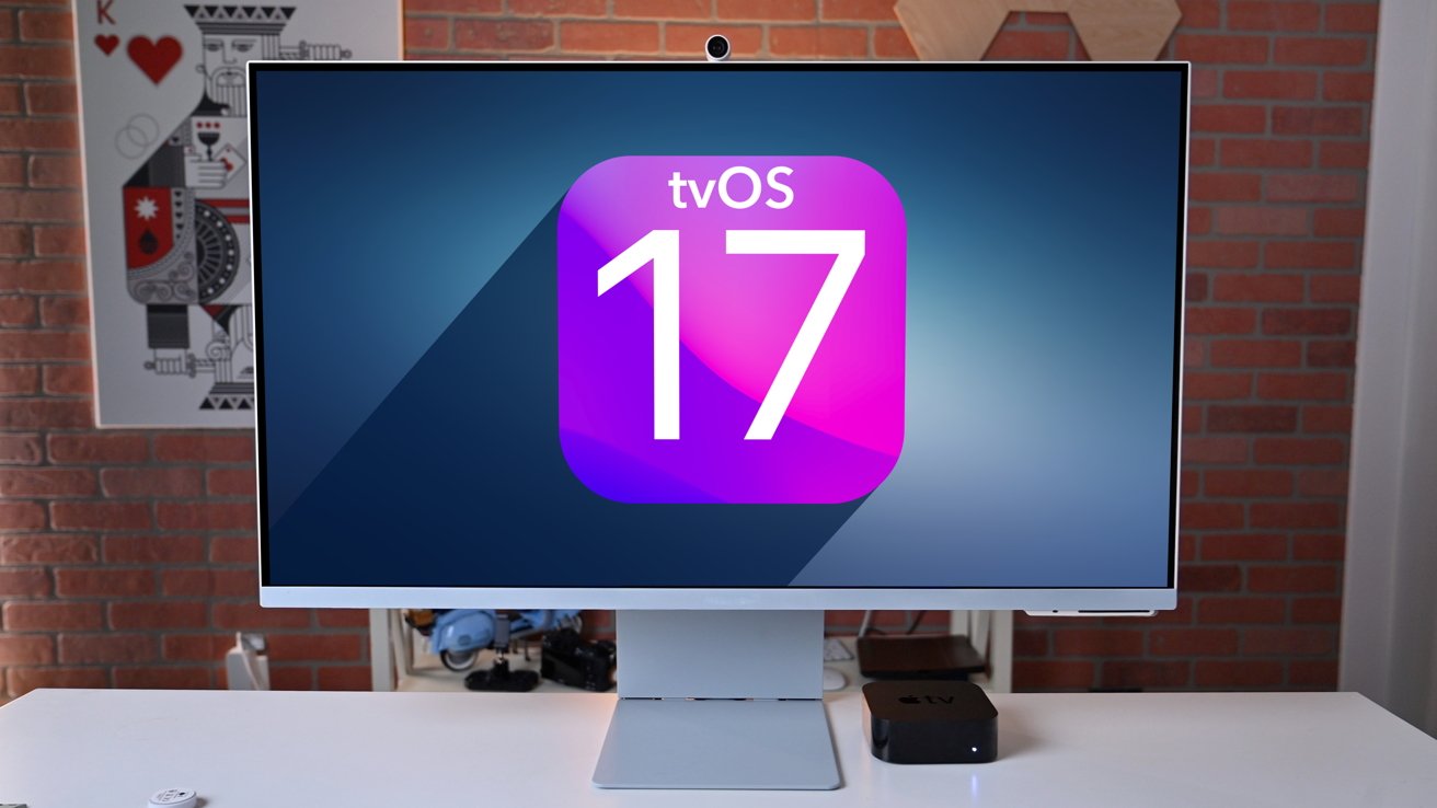 A computer monitor displays the tvOS 17 logo in a modern room with brick walls and a card poster. A small black device sits beside the monitor.