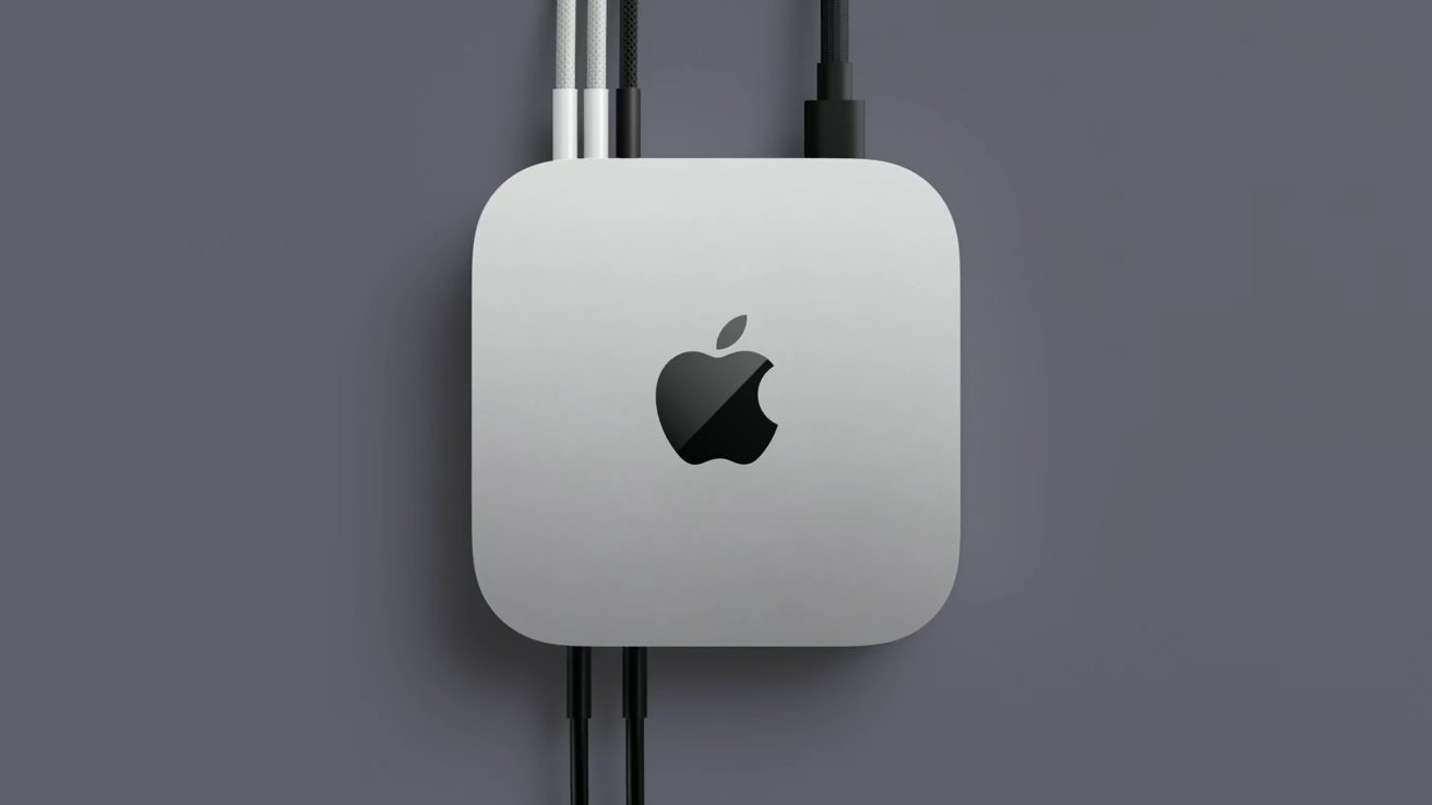 Silver square device with rounded edges, featuring an Apple logo and connected by multiple cables against a gray background.