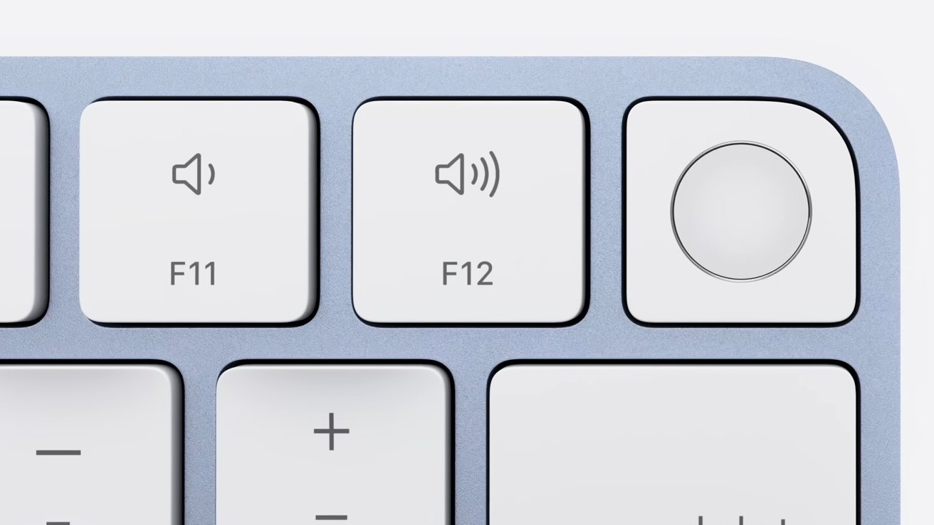 Close-up of a light gray keyboard showing F11, F12 keys with volume symbols and a circular button.