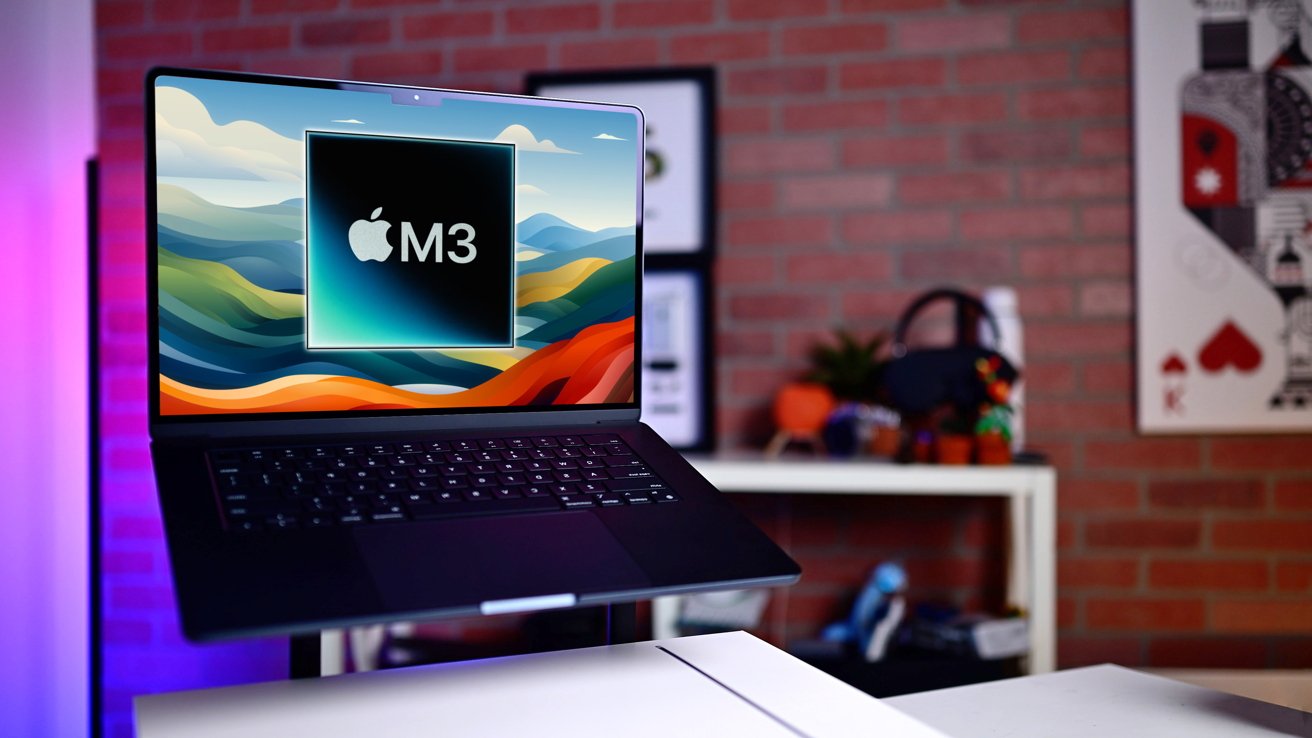 M3 MacBook Air on a table displaying a graphic with an Apple logo and 'M3' against a stylized backdrop, with a colorful shelf and brick wall in background.