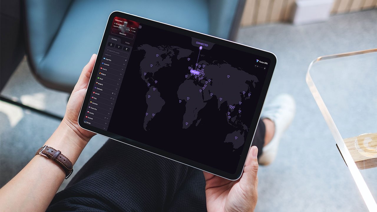 Hands holding a tablet displaying a global map with connection points and interface elements, suggesting digital connectivity through Proton VPN..