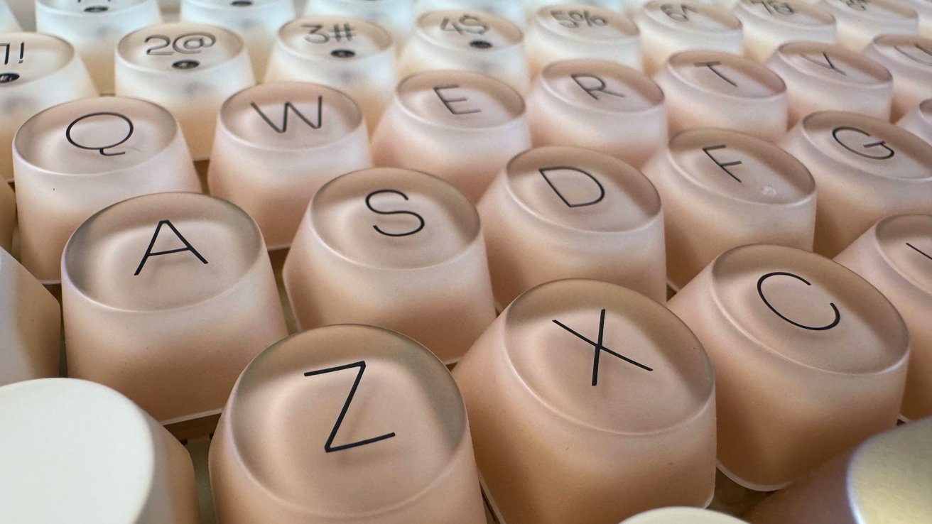 Close-up of translucent keyboard keys displaying letters and symbols, arranged in a grid pattern.