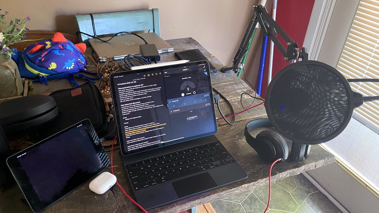 A photo of a mobile podcasting station taken in 2020 from a dining room table. The iPad could record local audio while a call was held on iPhone.