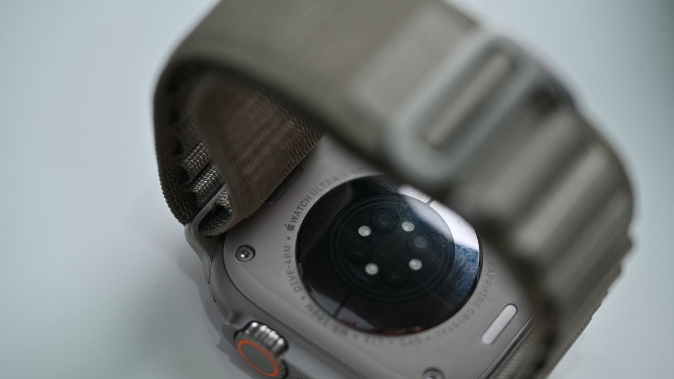 Apple Watch Ultra facedown on a table showing the health sensors