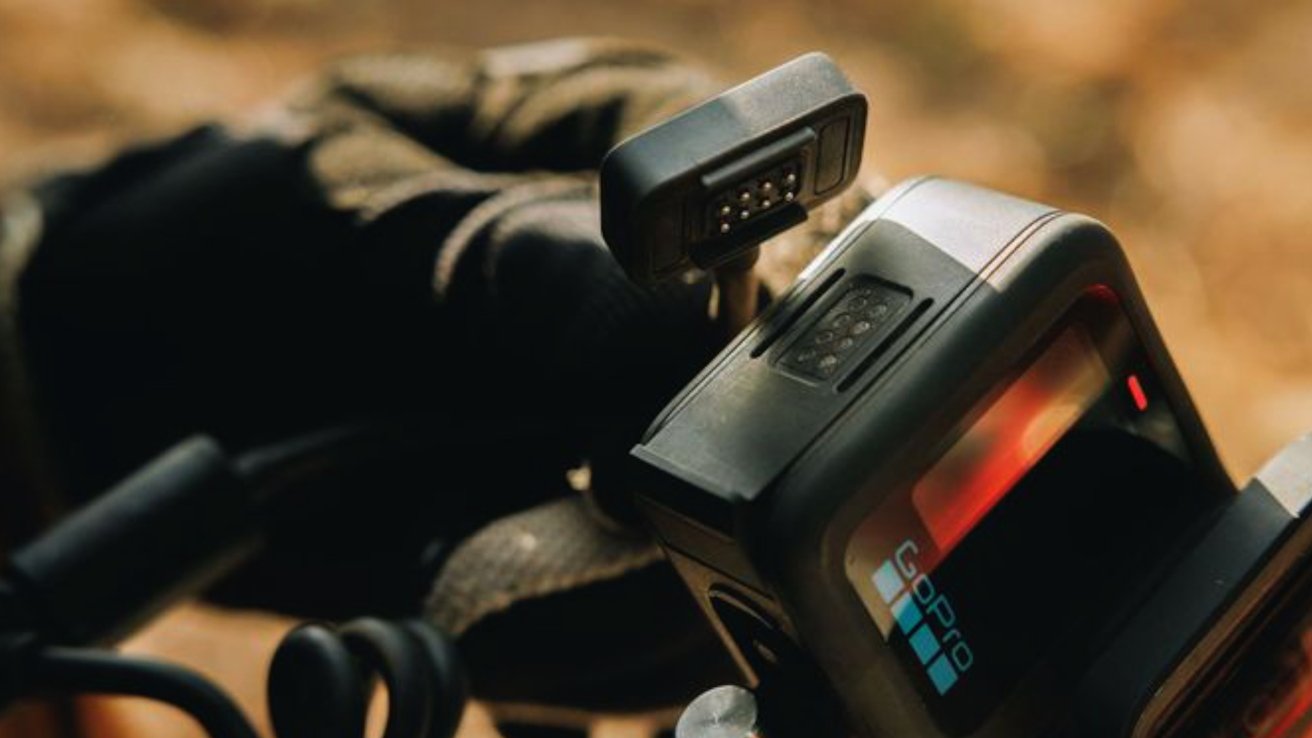 Someone wearing the GoPro Hero 13 Black on a backpack and connecting the magnetic charger to the side