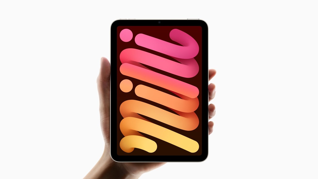 Hand holding a tablet with a colorful gradient design on the screen set against a plain white background.