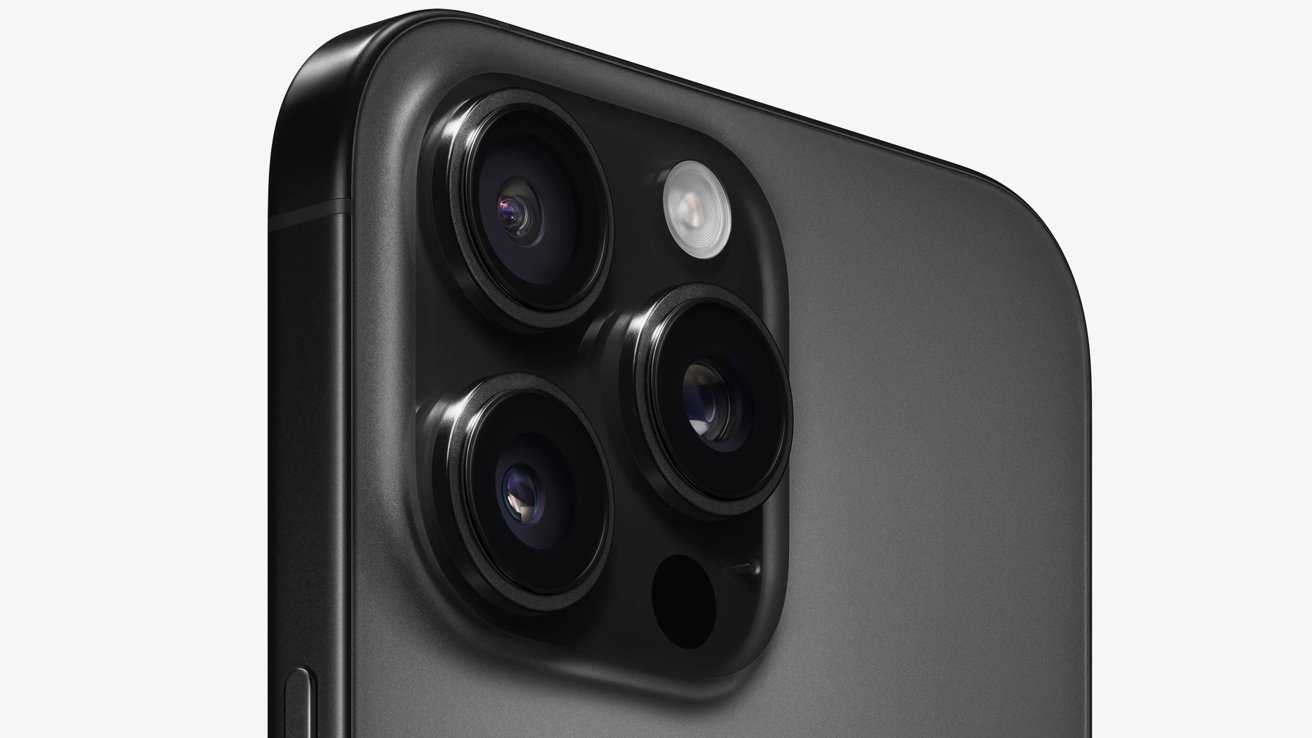 Close-up of a modern smartphone's rear camera system, featuring three lenses and a flash on a sleek, dark-colored surface.