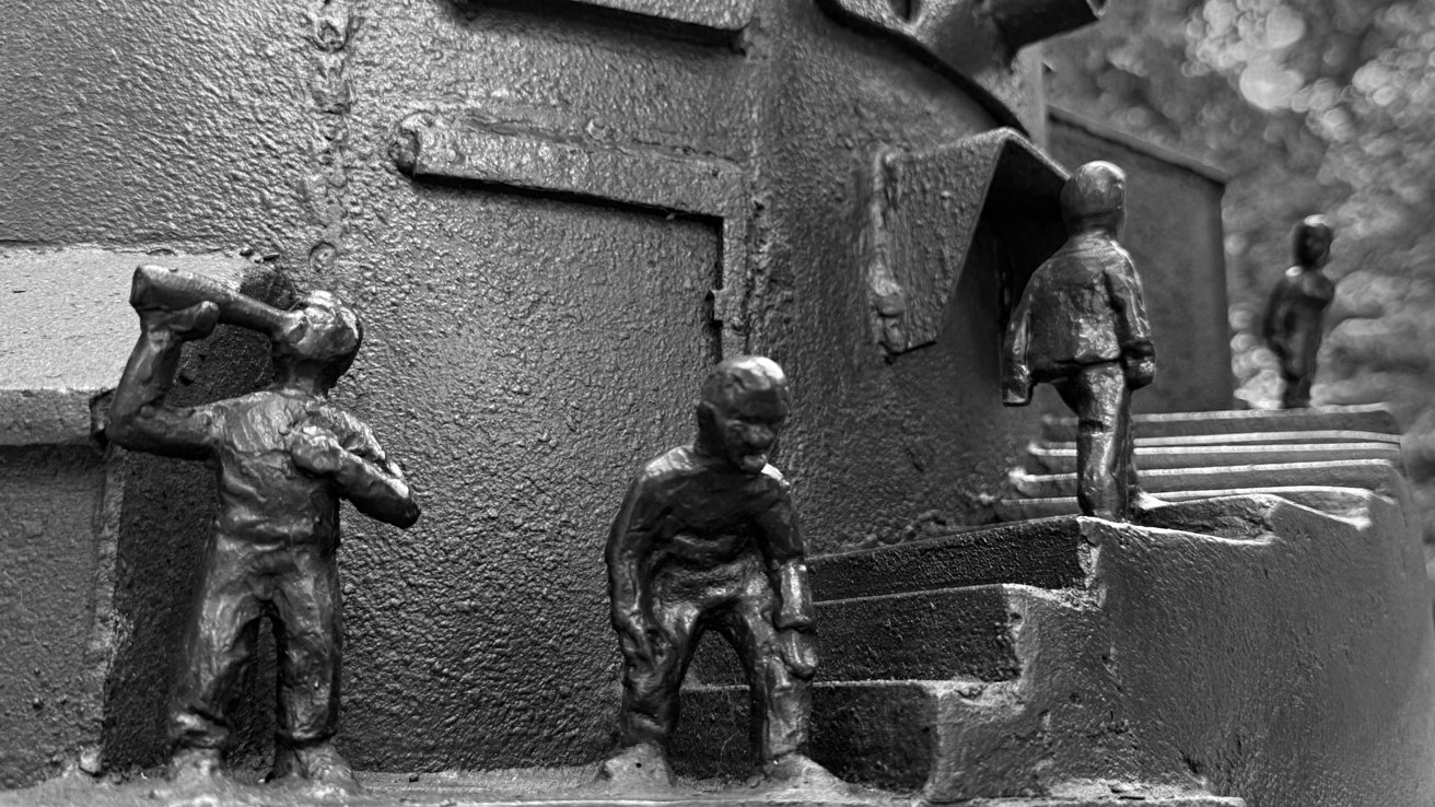 Bronze sculpture featuring small human figures engaged in various activities like drinking from a bottle, bending down, and climbing stairs.