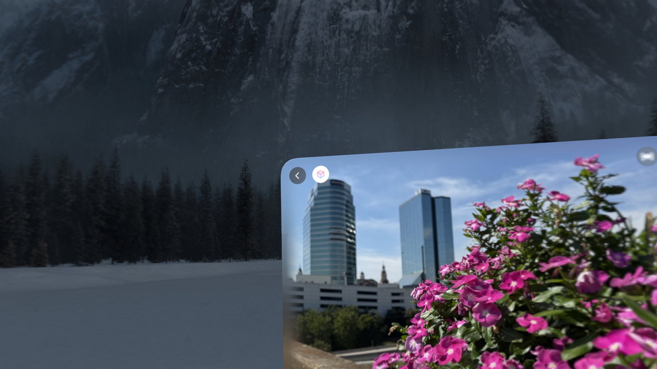 Tablet showing photo of skyscrapers and flowers in front of a foggy, snowy landscape with pine trees and steep mountains.