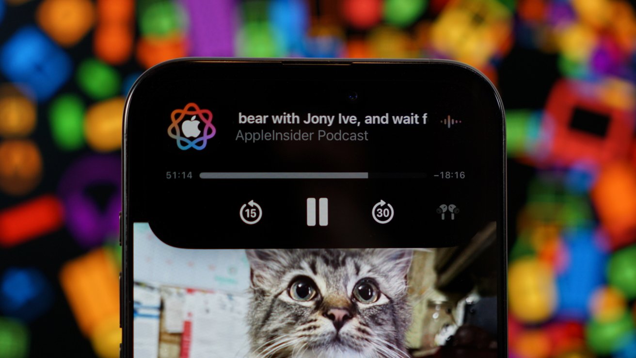 Smartphone showing a podcast titled 'bear with Jony Ive' and a paused image of a cat, with colorful background.