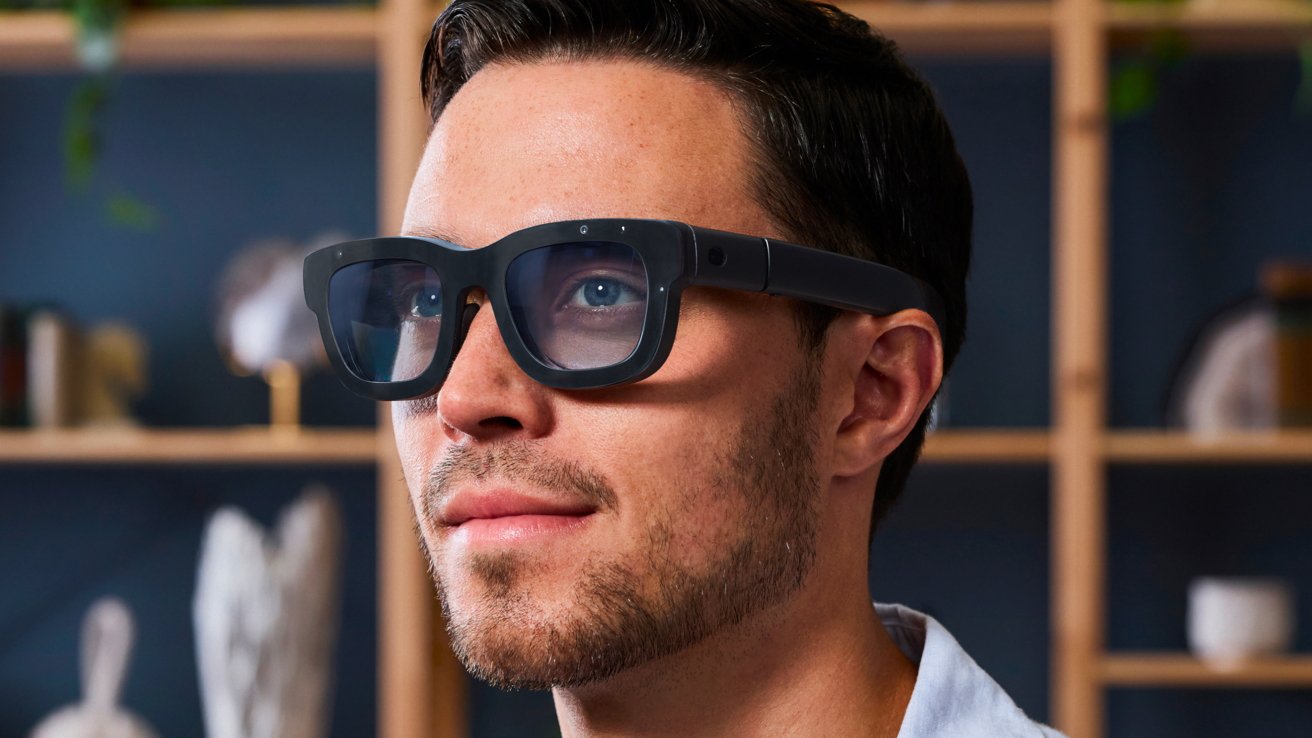 Man wearing smart glasses with a serious expression, background of shelves and shadows.