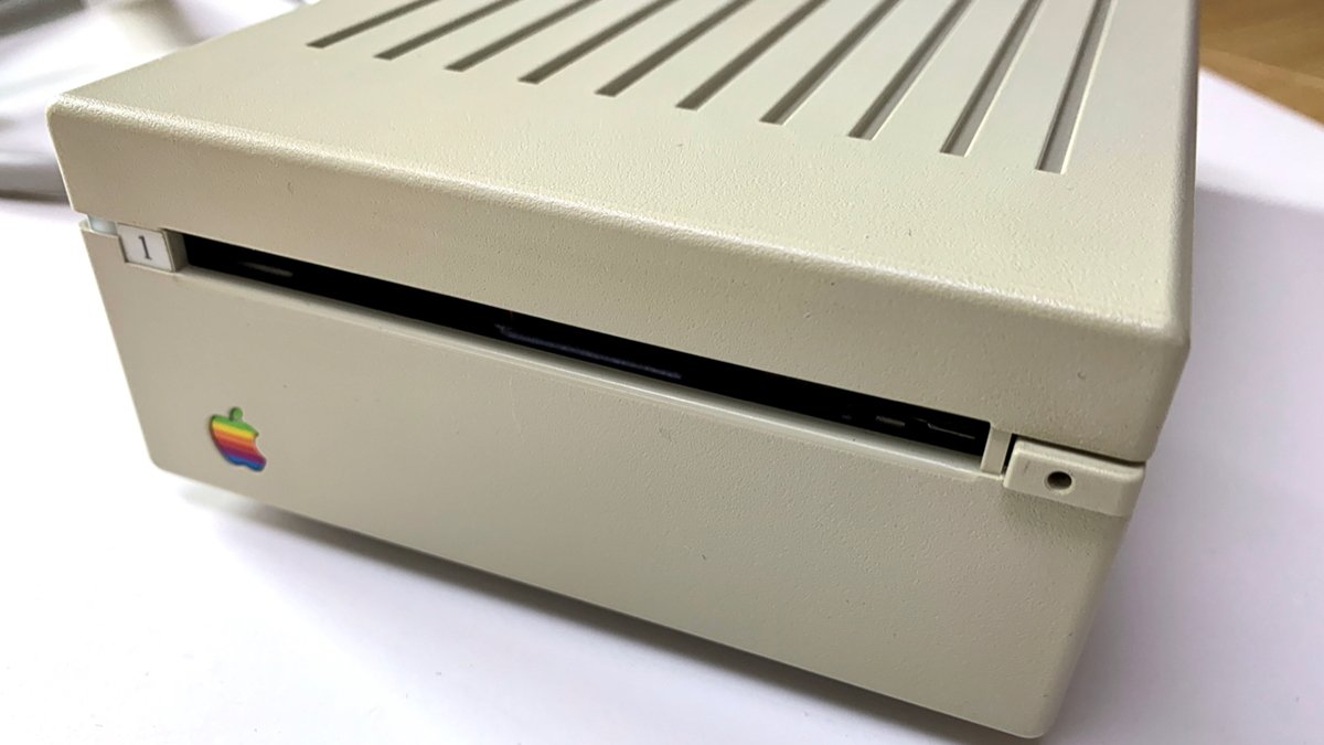 Vintage Apple 3.5-inch disk drive with a rainbow-colored apple logo on its front.