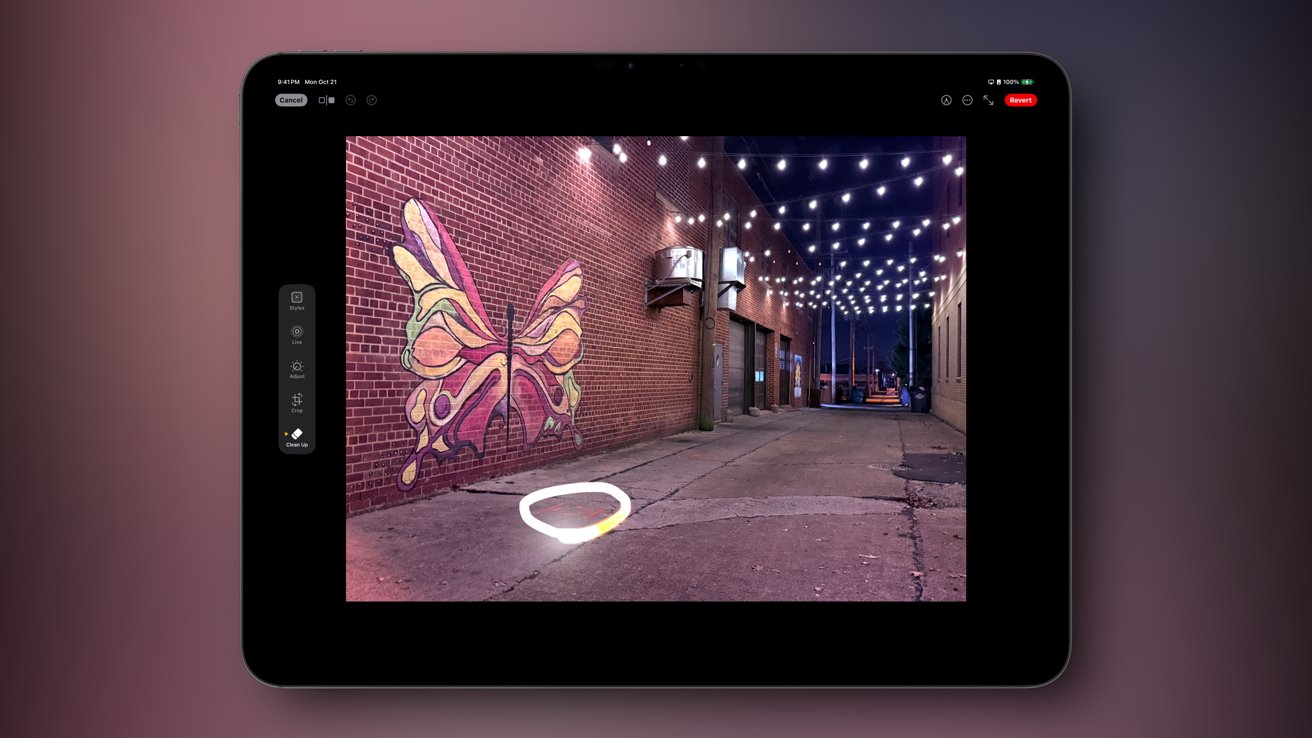 Tablet screen displays a brick alleyway with a colorful butterfly mural and overhead string lights.