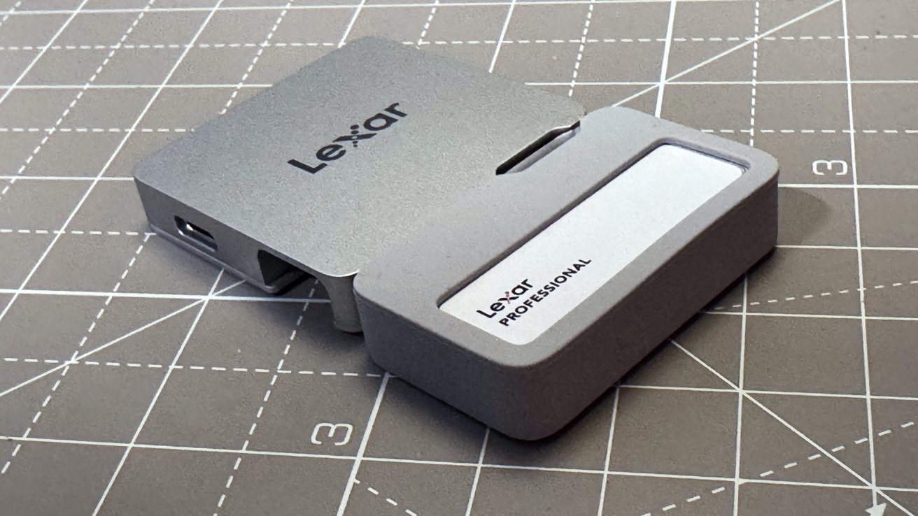 Silver Lexar Professional card reader on a grid-patterned surface.