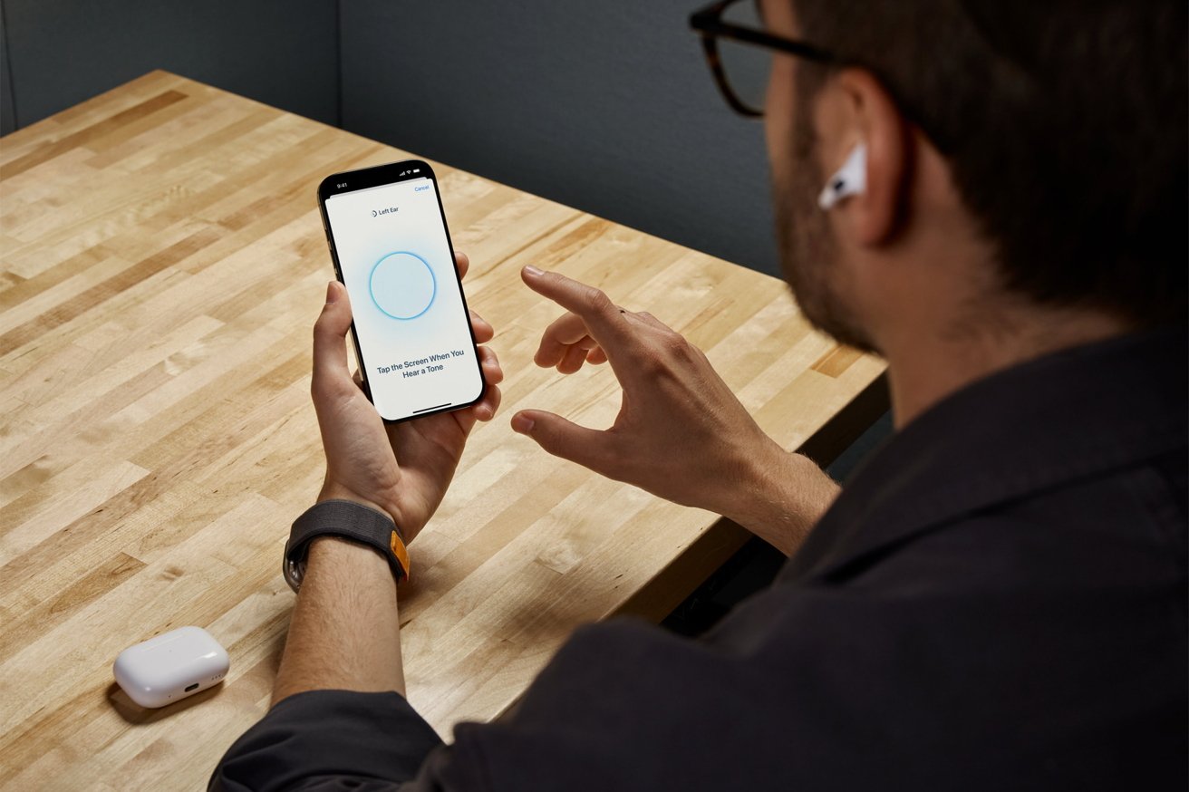 Person with AirPods using a smartphone app on a wooden table, with a white charging case nearby.