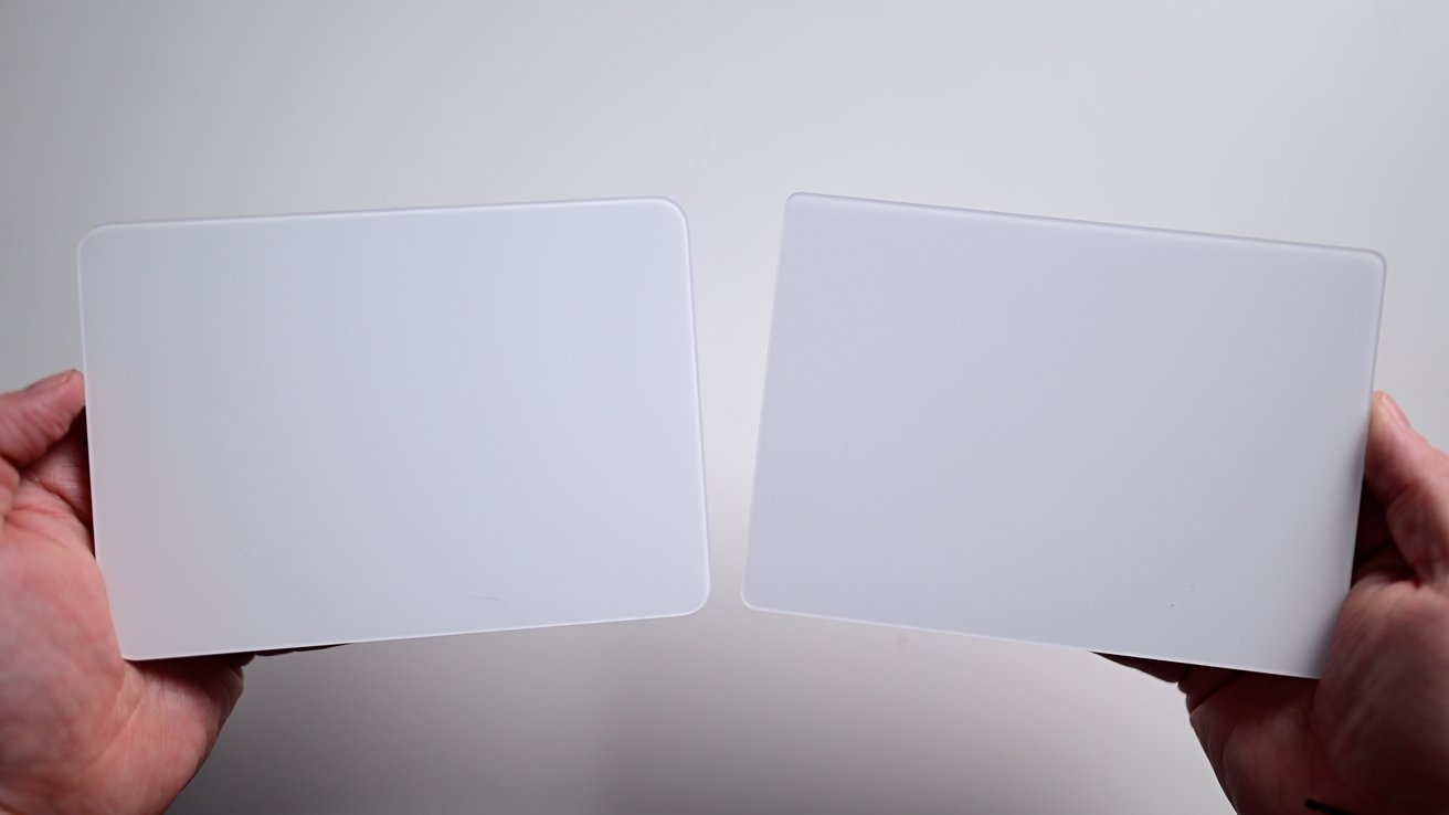 Two hands holding blank, white square boards against a plain background.