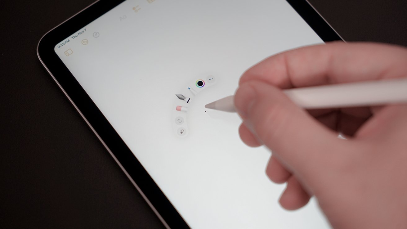 A person uses a stylus on a digital tablet, interacting with a color and tool selection menu on a white screen.