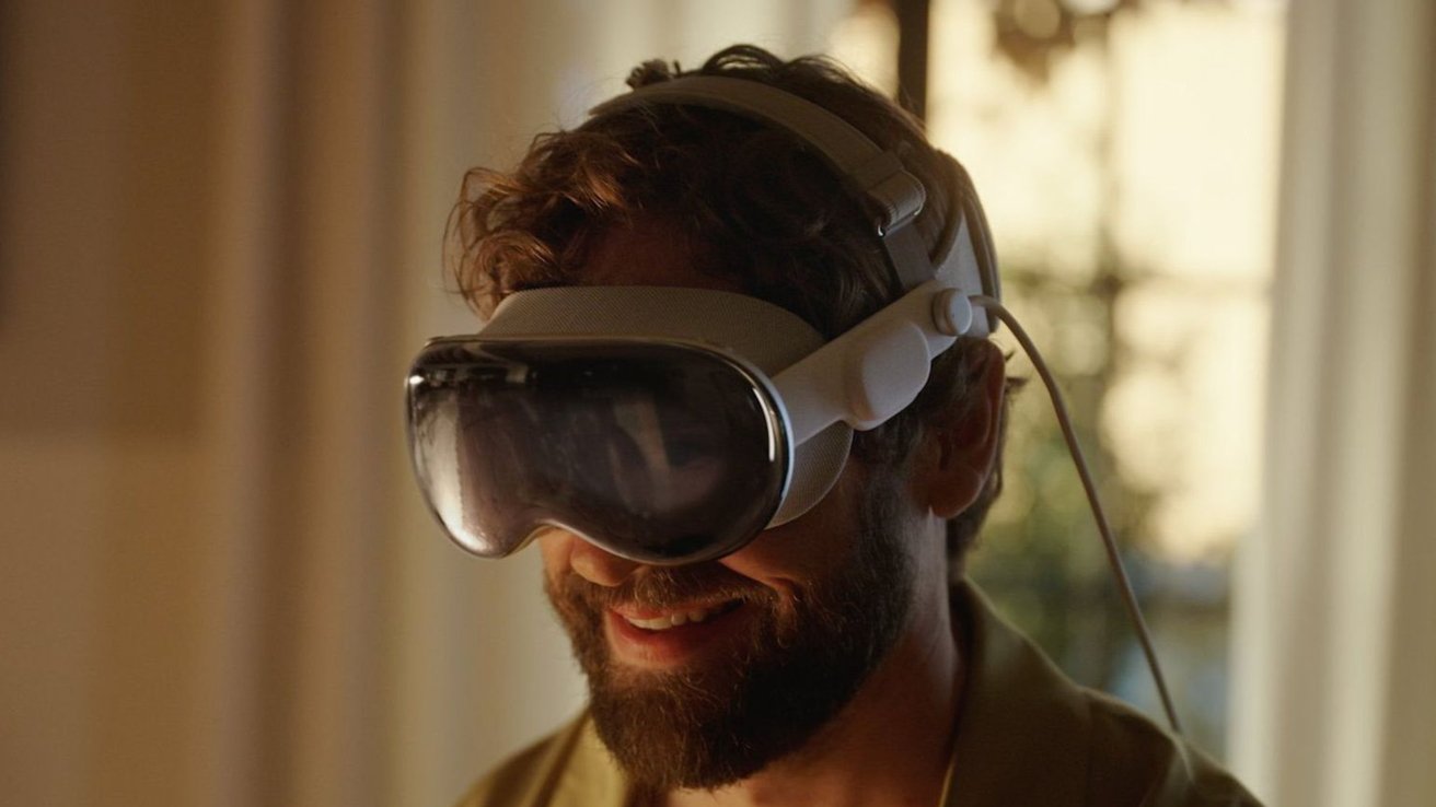 A person smiling while wearing a VR headset, with a blurred background and warm lighting.