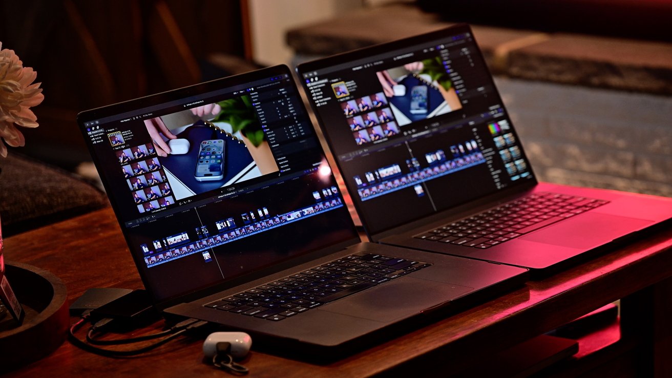 Two laptops on a wooden table display video editing software, with lighting creating a warm, cozy atmosphere.