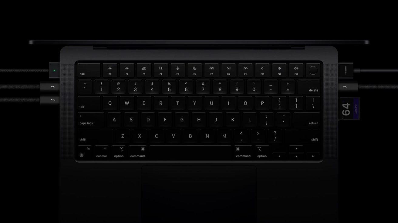 Black laptop keyboard with USB-C cables, HDMI cable, and 64GB SD card inserted into the ports on a dark background.