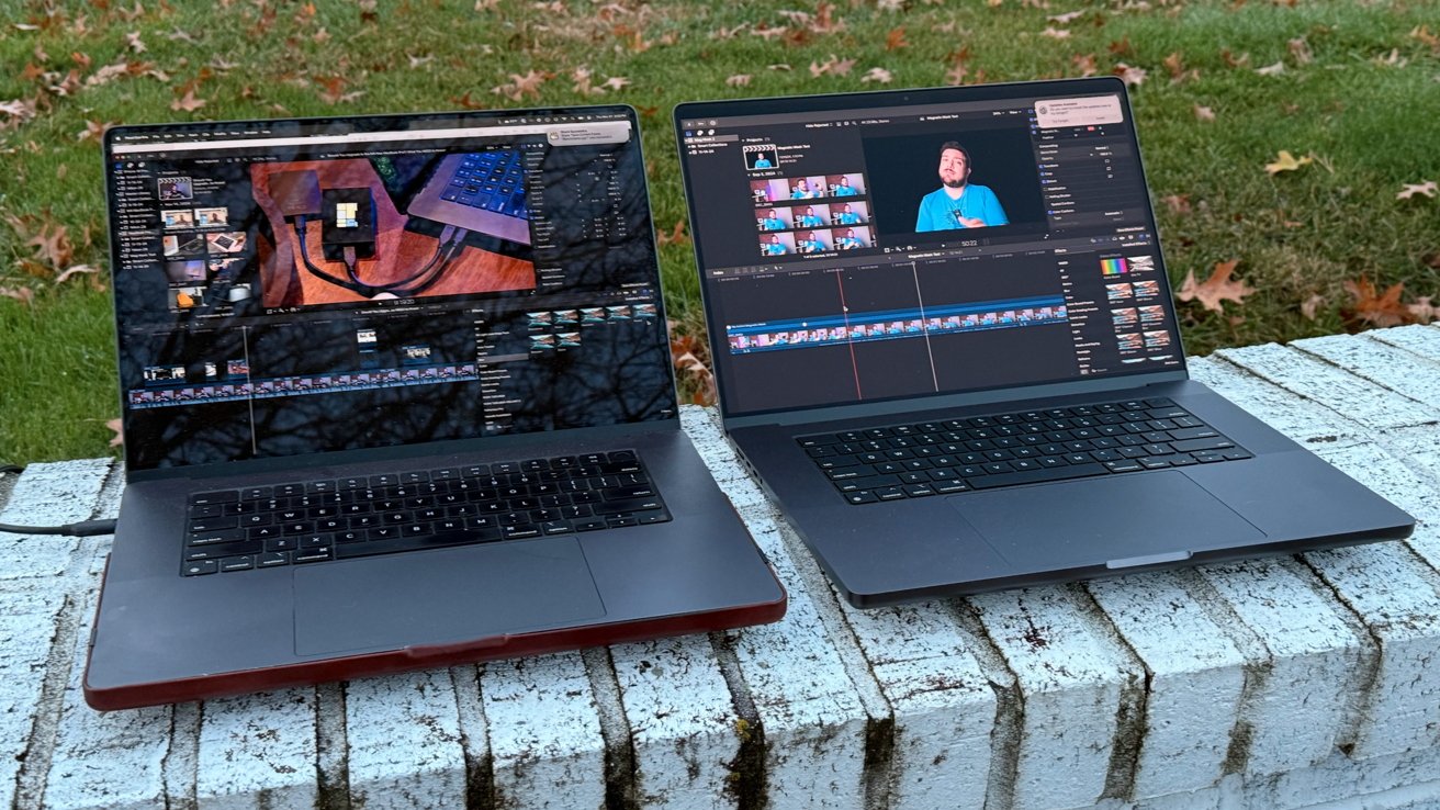 Two laptops on a white brick surface displaying video editing software with autumn leaves and grass in the background.