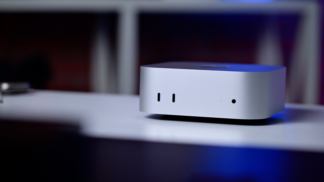 Silver compact rectangular device with rounded edges on a white surface; features minimal ports and a sleek design.