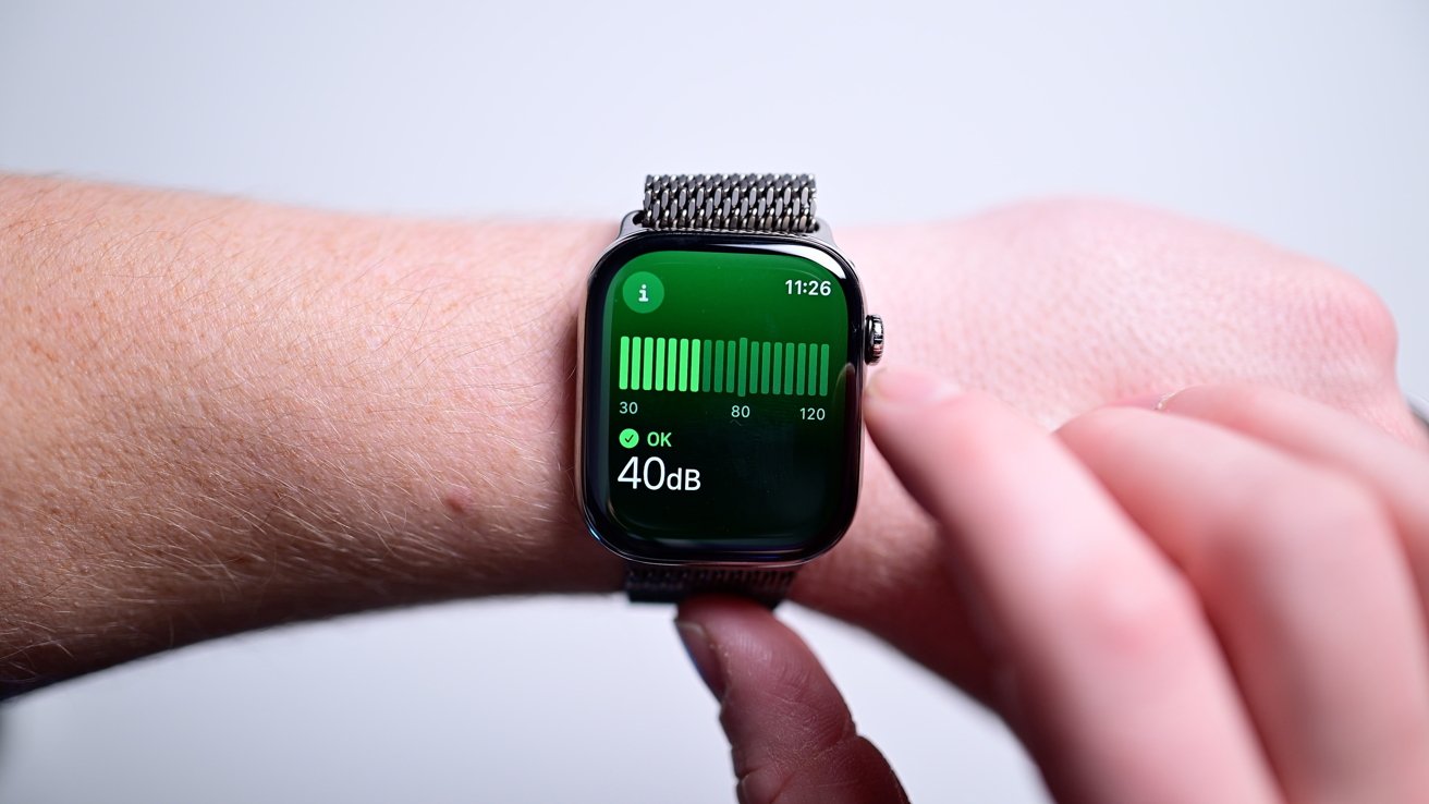 Smartwatch displaying a noise level of 40 decibels with a green bar graph, worn on a wrist with a metal band.