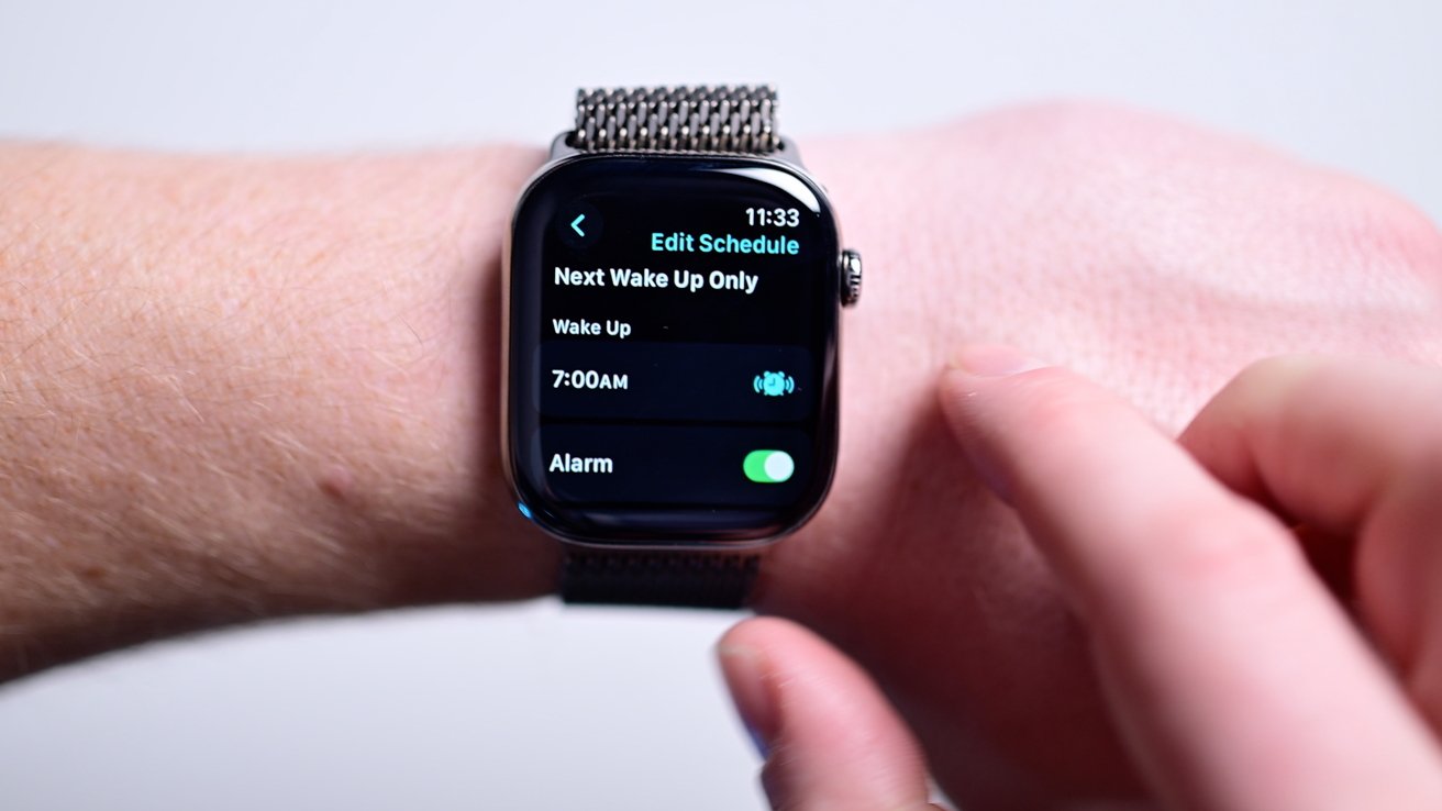 Person adjusting an alarm on a smartwatch set for 7:00 AM; 'Edit Schedule' and 'Alarm' toggle visible on screen.